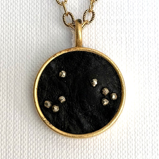 Aries zodiac constellation charm — black leather with hand-sewn pyrite beads, gold setting, on a fine cable link chain necklace