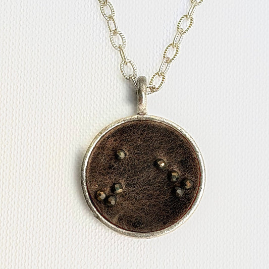 Aries zodiac constellation charm — Grey Ghost leather with hand-sewn pyrite beads, silver setting, on a fine cable link chain necklace