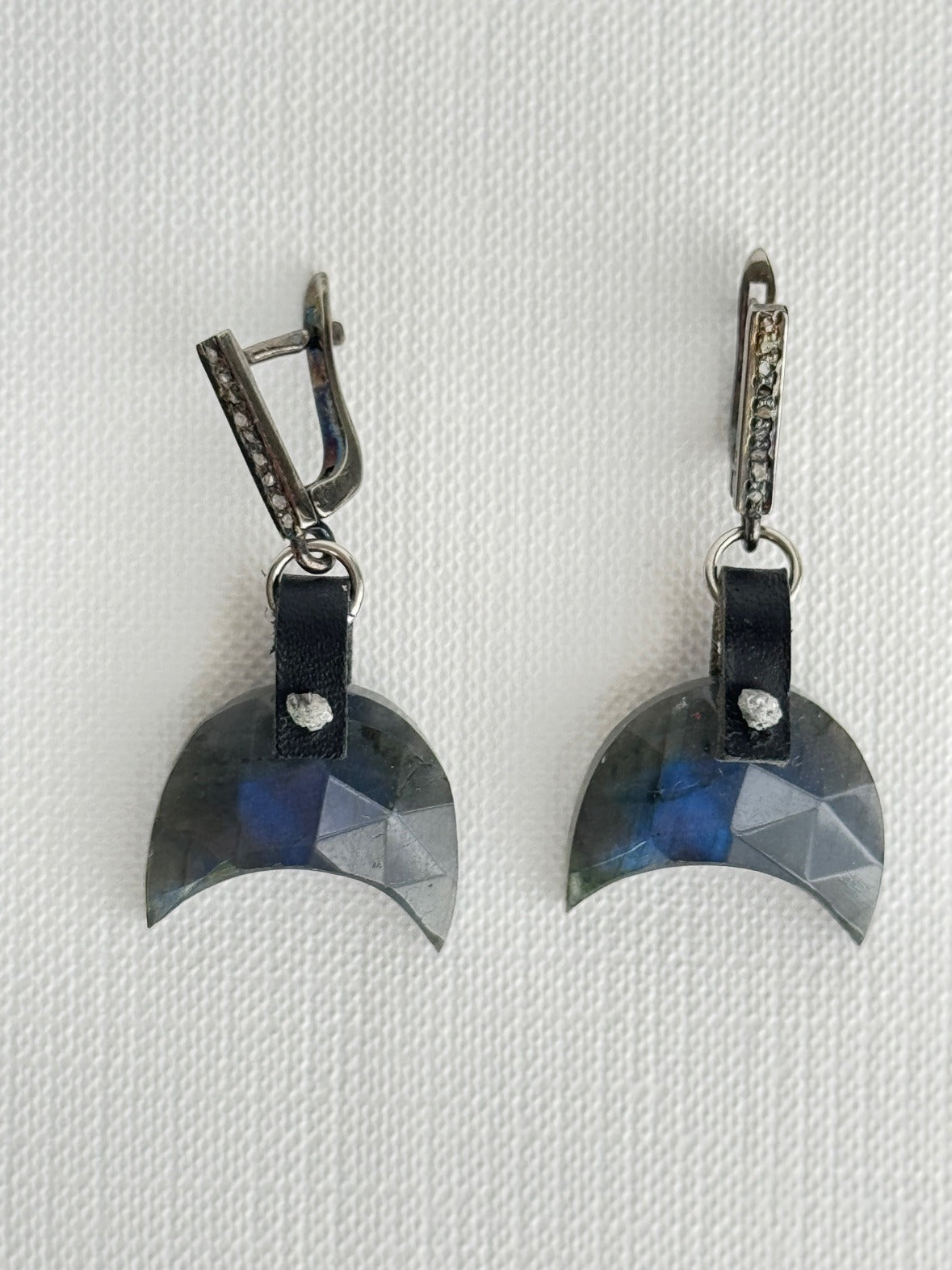Faceted labradorite crescent earrings with hand-sewn raw grey diamonds on black leather and oxidized sterling pavé diamond leverbacks, front view