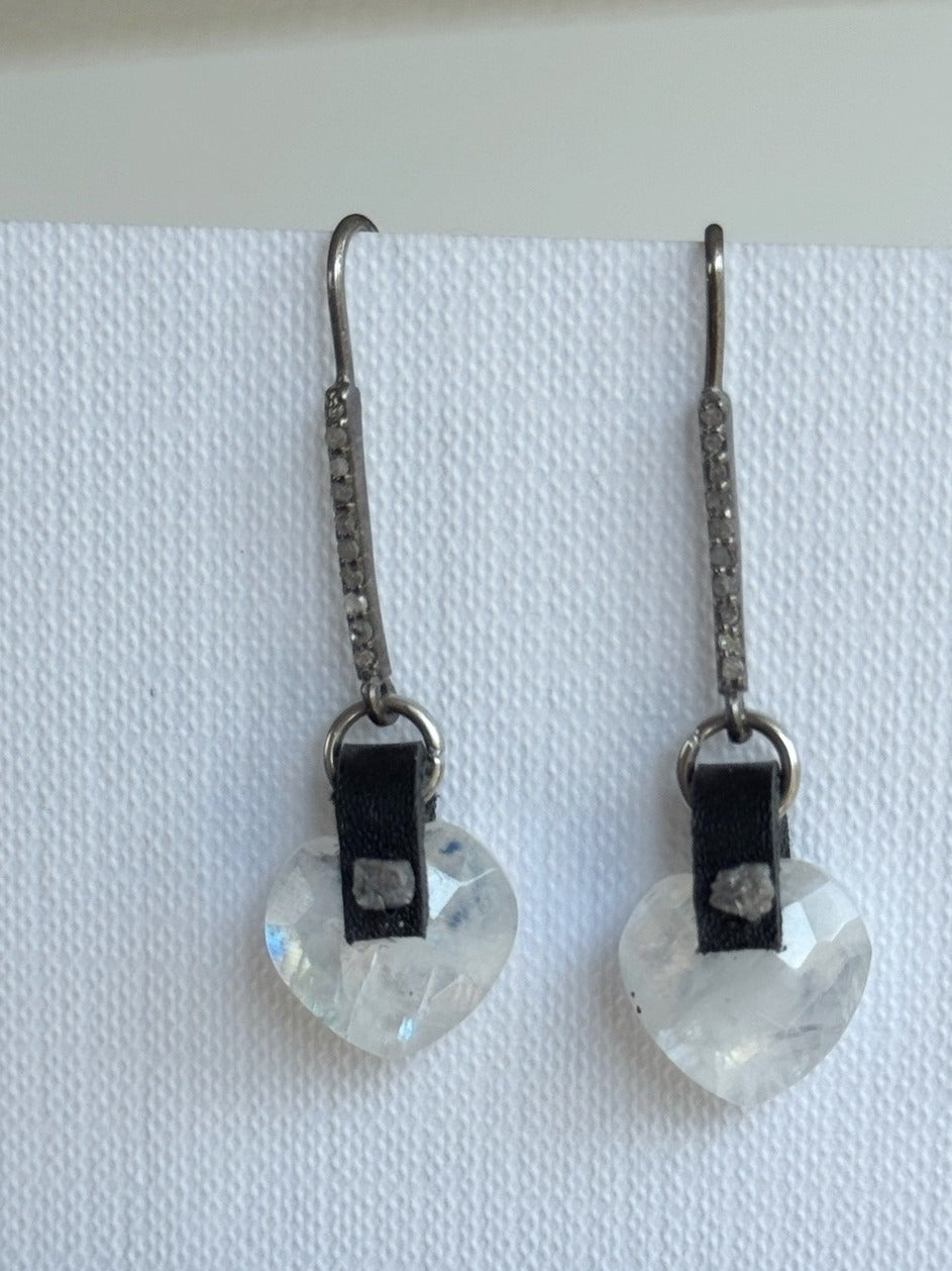 Faceted rainbow moonstone heart dangle earrings with a hand-sewn raw grey diamond on black leather and long oxidized sterling pavé diamond hooks, front view
