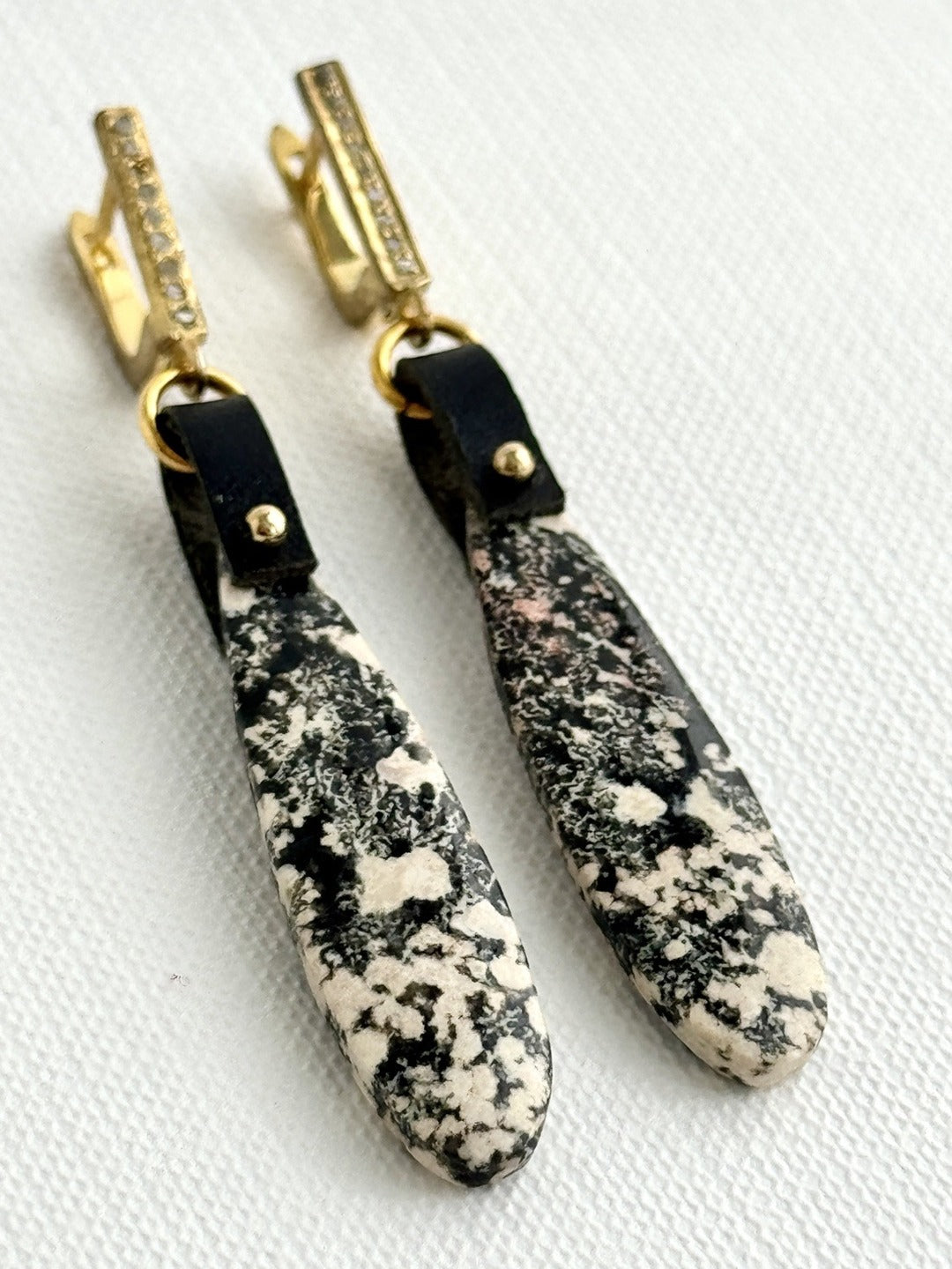 Snowflake obsidian teardrops lying angled, black leather, gold bead, pave diamond leverbacks
